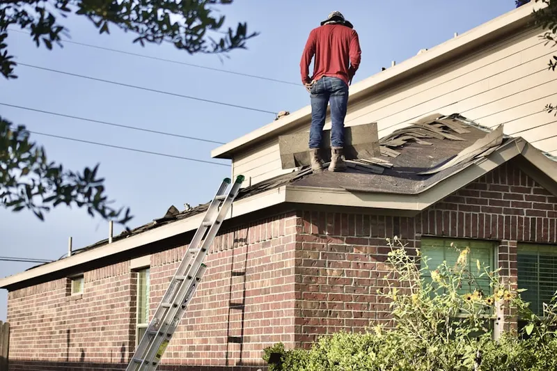 Professional roofer working on a residential roof in Califon